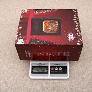 Detail view of Christmas book music box packaging box shown on scale with 1256g weight.