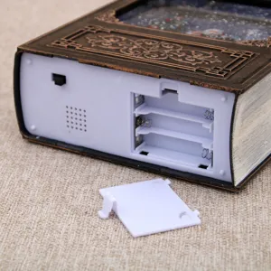 Detailed view of the battery compartment and switch on the vintage book music box base.