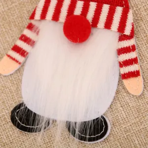 Close-up detail of Christmas gnome cutlery holder, red white striped hat plush white beard.