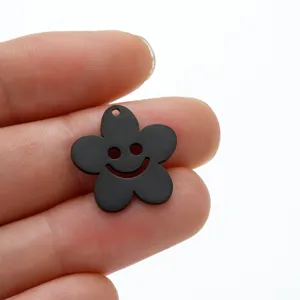 Détail de pendentif fleur visage souriant en acier inoxydable noir pour bijoux DIY.
