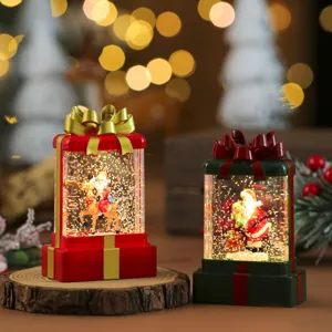 Veilleuse boule à neige de Noël vue de détail avec lumière LED et design de boîte cadeau.