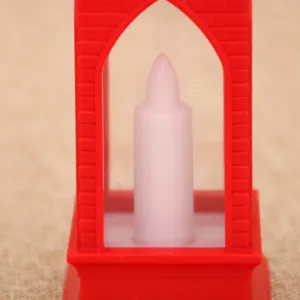 Close-up detail of red church shape electronic LED candle night light for Christmas decor.