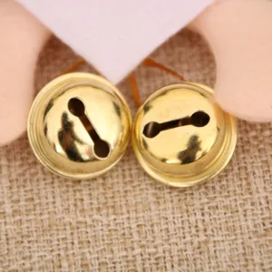 Gedetailleerde opname van gouden belletjes aan een kerstpop-hanger voor feestelijke boomdecoratie.