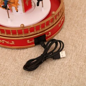 Close-up detail shot of the USB power cable connected to a Christmas musical carousel decoration.