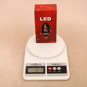Christmas LED water globe night light detail shot, showing packaging box and weight scale display.