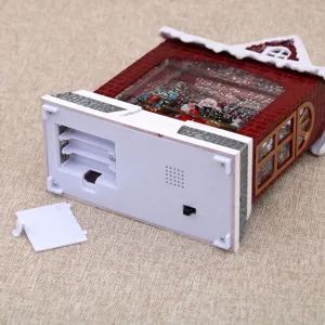 Close-up detail showing the battery compartment and switch of the Christmas snow globe.