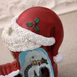 Close-up detail shot of resin Christmas Santa boot micro landscape ornament with snow scene.