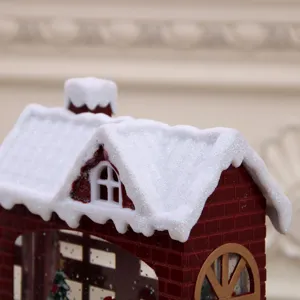 Christmas snow globe lantern detail, red brick house with snowy roof, festive home decor.