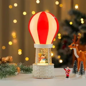 Christmas hot air balloon snow globe music box close up view with festive decor.