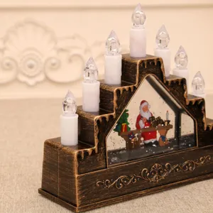 Detalle de lámpara vela navideña decorativa, caja música bola agua, adorno de mesa.