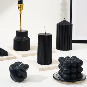 Vue de détail de bougies parfumées noires assorties aux designs géométriques texturés.