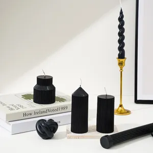 Ensemble de bougies parfumées noires, bougies torsadées et piliers pour décor romantique.