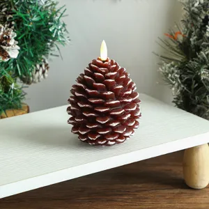Gros plan détaillé d'une bougie LED en forme de pomme de pin de Noël avec effet de neige.