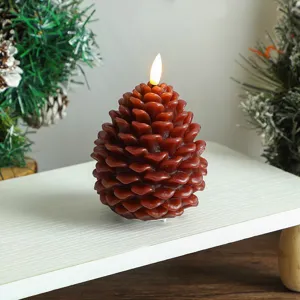 Bougie LED en forme de pomme de pin pour Noël, texture cire réaliste et lueur festive chaleureuse.