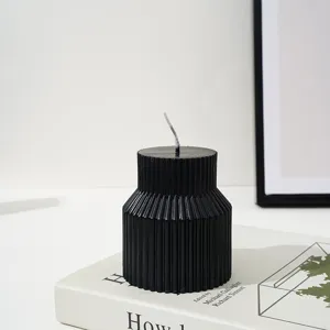 Gros plan d'une bougie parfumée pilier côtelée noire élégante, esthétique de décoration.