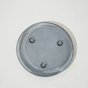 Détail de plateau à bougie en verre gris, assiette ronde minimaliste pour bougies.