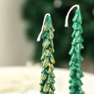 Christmas tree scented candle detail shot, green and gold festive home decor wax.