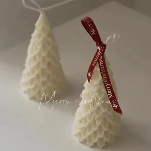Handmade white Christmas tree scented candle with red ribbon, perfect for holiday home decor.
