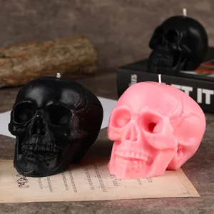 Detailansicht von Halloween Totenkopf Duftkerzen in Schwarz und Rosa für gruselige Deko.