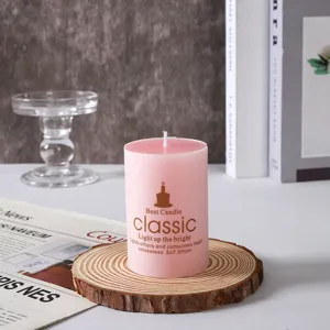 Primo piano dettagliato di una candela profumata cilindrica rosa su supporto in legno.