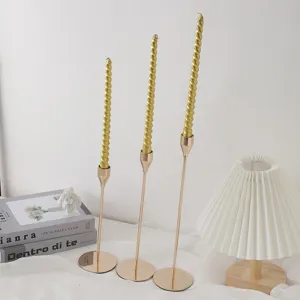 Eleganti candele lunghe a spirale in supporti dorati per decorazioni di matrimoni e casa.