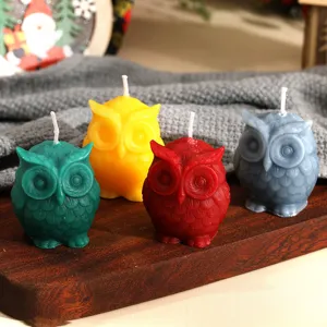 Set di quattro candele profumate a forma di gufo su vassoio di legno per decorazione.