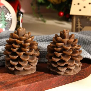 Candela profumata a pigna di Natale dettaglio, cera marrone per decorazione festiva.