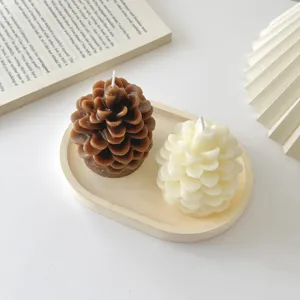 Detail shot of cute pinecone scented soy candles on a tray, cozy home decor and holiday gift prop.