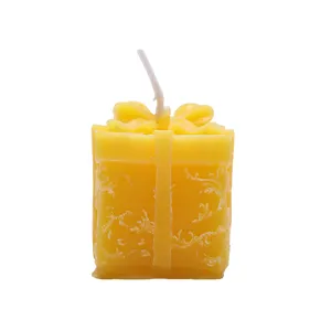 Candela profumata a forma di pacco regalo con fiocco e rilievo floreale per decorare casa