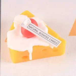 Detailed close-up view of the cute cheese cake scented candle featuring cream and red cherry.
