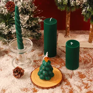 Vue détaillée de bougies parfumées de Noël avec décors de pommes de pin et de neige.