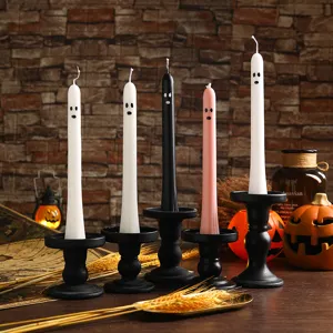 Halloween ghost long taper candles with black candle holders and festive decor props.