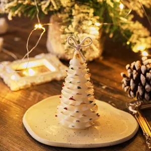 Vista detallada de vela aromática de cera de soja con forma de árbol de navidad.