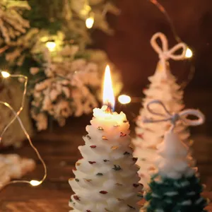 Detalle de primer plano de vela aromática de árbol de Navidad con luces cálidas y decoración.