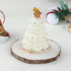 Christmas tree scented candle detail showing the white wax texture and golden star ornament.