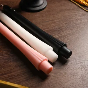 Close-up detail of colorful long tapered candles with ghost design on wooden table background.