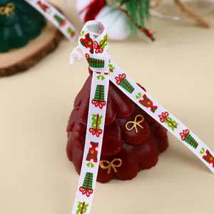 Detailaufnahme einer festlichen Weihnachtsbaum Duftkerze dekoriert mit einem Geschenkband.