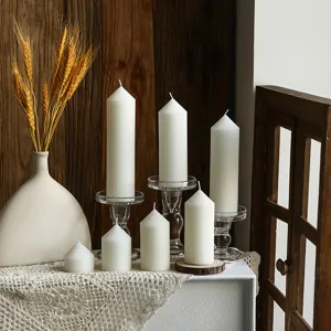 Close-up view of white ribbed pillar scented candles in Nordic minimalist geometric design.