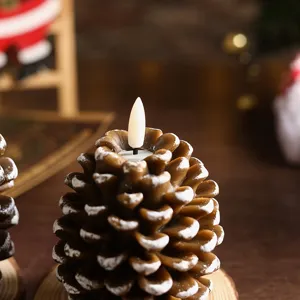 Pinecone shaped LED candle detail shot with snow texture for festive Christmas decor.