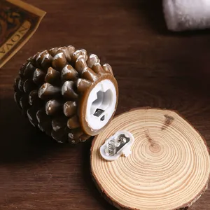 Christmas LED pine cone candle detail view, paraffin wax warm light decorative lamp.
