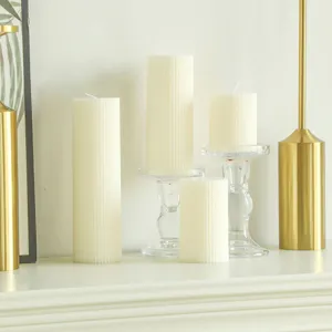 Detailed view of white Nordic striped pillar scented candles displayed with glass candle holders.