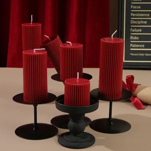 Red striped pillar scented soy wax candles with black metal candle holders for home decor.
