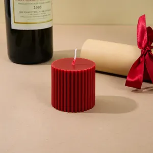 Red fluted scented candle close up detail view, soy wax home decor ornament prop.