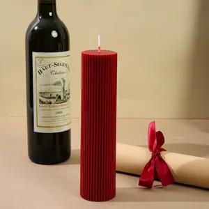 Close-up of red ribbed pillar soy wax candle for home decor, cozy atmosphere detail shot.