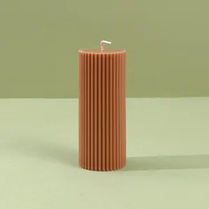 Primer plano detallado de una vela de pilar marron estriada con diseño de columna.