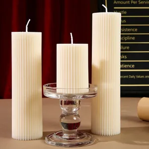 Vue de détail de bougies parfumées en cire de soja cylindriques rayées, accessoires de déco.