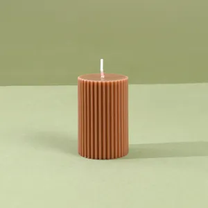 Primer plano detallado de vela aromática de pilar acanalado marrón, decoración vintage.