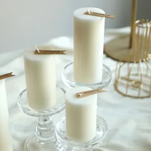Primo piano dettagliato di candele profumate cilindriche bianche su eleganti portacandele.