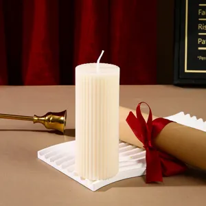 Vue détaillée d'une bougie parfumée cylindrique côtelée blanche en cire de soja.