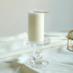 Primo piano di candela pilastro bianca su portacandela in vetro, elegante decorazione.